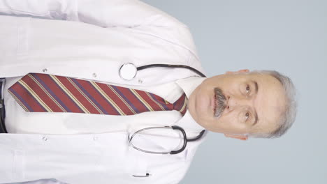 Vertical-video-of-Old-doctor-shows-correct-coughing.